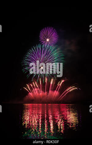 Rich and colorful fireworks over surface of Brno's Dam with reflection on the surface of lake Stock Photo