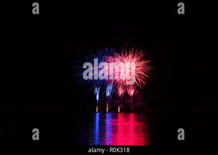 Red and blue rich stars from fireworks over surface of Brno's Dam with reflection on the surface of lake Stock Photo