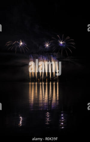 Gold and blue fountain in rich fireworks over surface of Brno's Dam with lake reflection Stock Photo