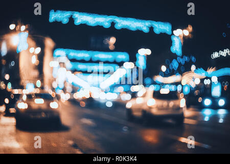 Blurred city at night. Bokeh. Beautiful abstract scene with defocused buildings, cars, city lights, people. Colorful bokeh background with urban night Stock Photo