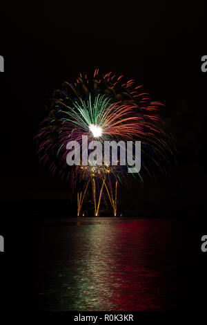 Magnificent colorful stars and fountain from rich fireworks over Brno's Dam with lake reflection Stock Photo