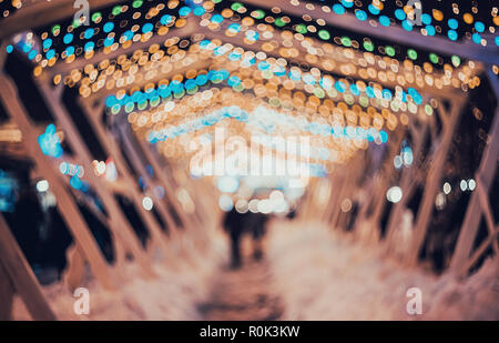 Blurred city with christmas lights at night. New Year bokeh background. Beautiful abstract background with defocused city lights, people. Defocused ur Stock Photo