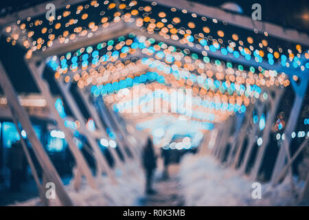 Blurred city with christmas lights at night. New Year bokeh background. Beautiful abstract background with defocused city lights, people. Defocused ur Stock Photo