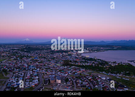 Aerial view of the city of Puerto Montt at dusk, the Osorno and Calbuco volcanoes are visible in the background Stock Photo