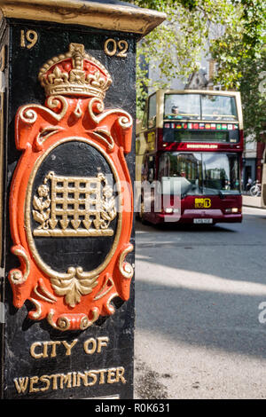 London England,UK,Covent Garden Strand,City of Westminster,lamp post base,shield coat of arms,Big double-decker bus,UK GB English Europe,UK180823042 Stock Photo