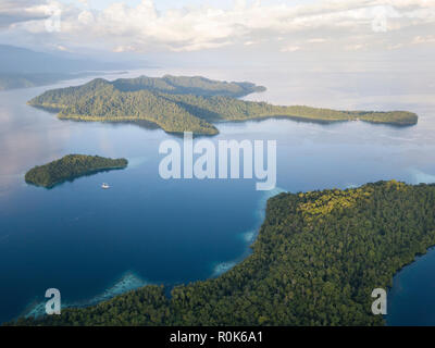 A Pinisi schooner sits at anchor in a remote area of Raja Ampat in eastern Indonesia. Stock Photo