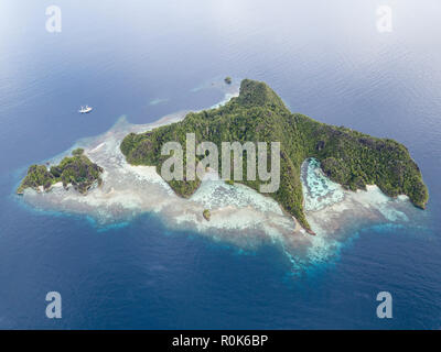 A Pinisi schooner sits at anchor in a remote area of Raja Ampat in eastern Indonesia. Stock Photo