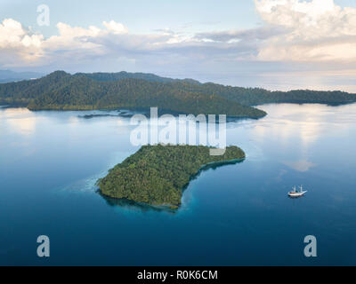 A Pinisi schooner sits at anchor in a remote area of Raja Ampat in eastern Indonesia. Stock Photo