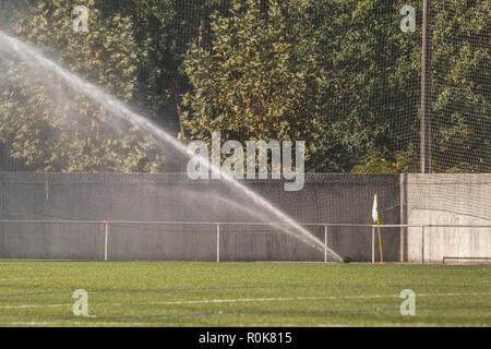 sprinkler watering to green grass field in football / soccer stadium Stock Photo