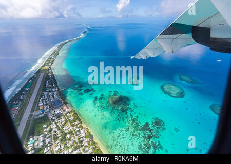 Tuvalu, Polynesia under the wing of an airplane. Aerial view of Funafuti atoll and the airstrip of International airport in Vaiaku. Island nation. Stock Photo