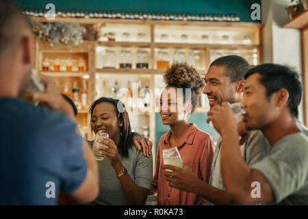 Diverse young friends hanging out together in a bar  Stock Photo