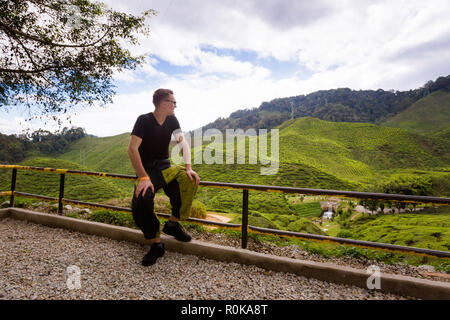 Landscape with young tourist on Bharat tea plantation in Cameron Highlands mountains in national park in Malaysia. Agriculture of south east Asia. Stock Photo