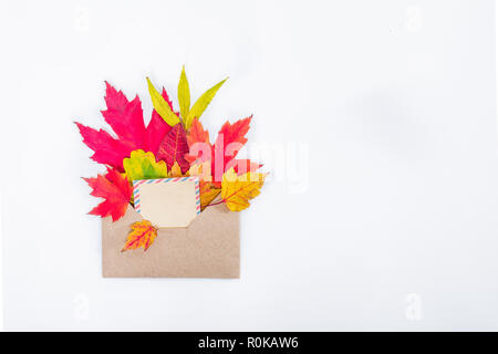 Top view flat lay autumn concept composition. Craft envelope with blank card and autumn leaves on white background isolated. Mock up fall thanksgiving Stock Photo