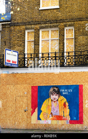 Graffiti art featuring a depiction of Pete Doherty eating a full English cooked breakfast on a hoarding of a boarded up property for sale in Southend Stock Photo