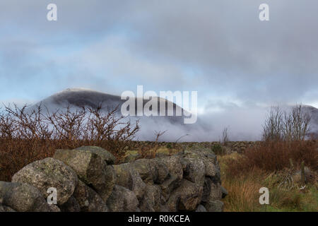 Slieve Lamagan mountain shrouded in low level mist beyond dry stone wall. Mourne Mountains, N.Ireland. Stock Photo