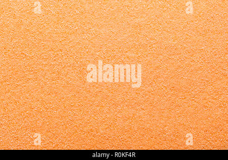 Flat Pile of Orange Sugar Grain Textured Background. Stock Photo