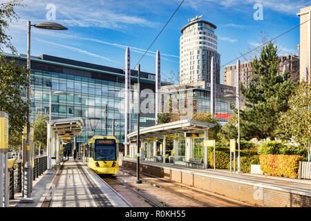 2 November 2018: Manchester, UK - Metrolink tram at Media City UK Station on a sunny autumn day with blue sky.