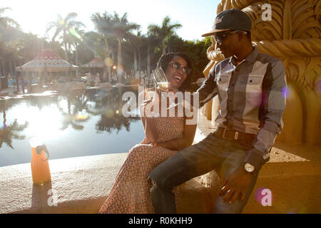 Couple toasting at the poolside Stock Photo