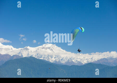 Tandem paragliders float over Nepal with the Annapurna Himalayas in the background Stock Photo