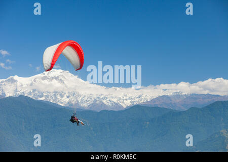 Tandem paragliders float over Nepal with the Annapurna Himalayas in the background Stock Photo