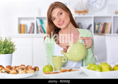 Portrait of beautiful young woman pouring tea in cup Stock Photo