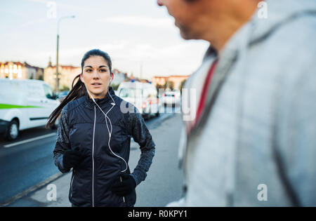 A fit young female runner running outdoors on the bridge in Prague city. Stock Photo