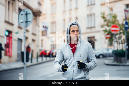 Mature male runner running outdoors on the street in Prague city.