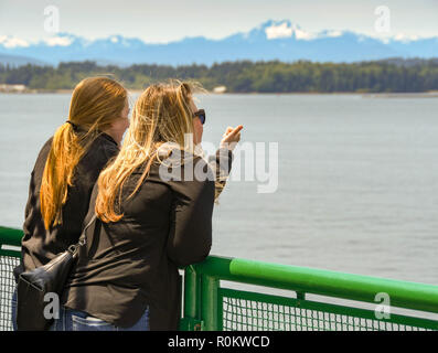 EN ROUTE SEATTLE TO BREMERTON - JUNE 2018: Person pointing out something of interest to her friend on a passenger ferry from Seattle to Bremerton. Stock Photo