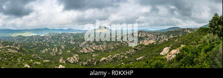 Panoramic view of Monte Genova in the Desert des Agriates in the north of Corsica. The 421m high peak is pictured under a dramatic grey cloudy sky. Stock Photo