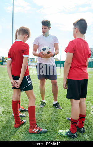 Coach Talking to Junior Football Team Stock Photo