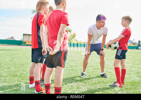 Coach Motivating Young Football Players Stock Photo