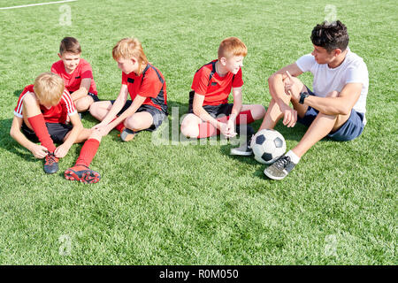 Junior Football Team Resting in Sunlight Stock Photo