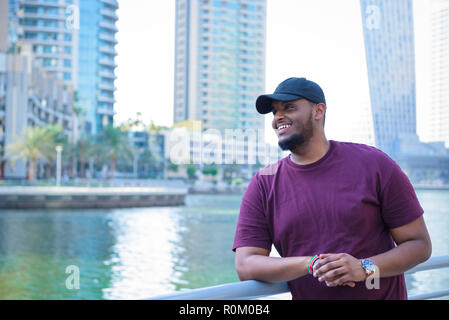 Middle Eastern African man looking out having fun at the marina Stock Photo