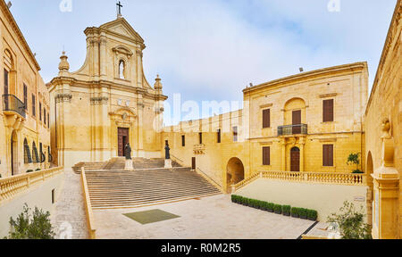 The stone Cathedral Square of Rabat Citadel with a view on modest facade of Assumption Cathedral, built of native limestone, Victoria, Gozo Island, Ma Stock Photo