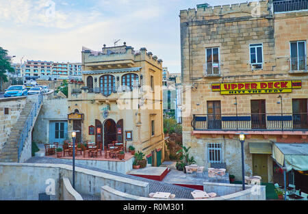 GHAJNSIELEM, MALTA - JUNE 15, 2018: The old edifices at the Mgarr Harbour with tourist hotels, cafes and restaurants, on June 15 in Ghajnsielem. Stock Photo