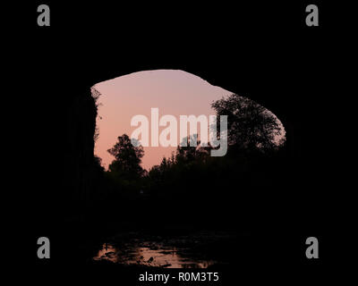 Sun set over Devetashka Cave, Bulgaria, north east of Lovech. It is a karst cave over 2 kilometers long and home to 30,000 bats. Stock Photo