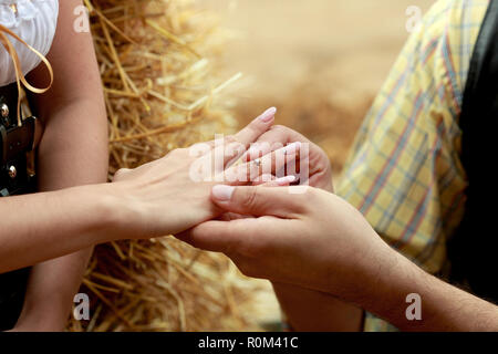 Close up on hand of a man put on an engagement ring on the finge Stock Photo