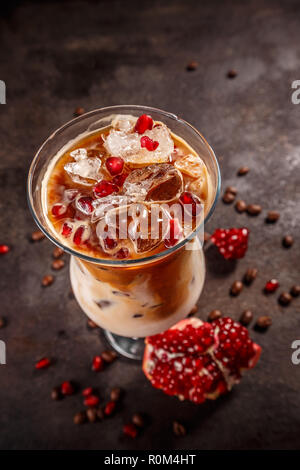Iced coffee with milk in tall glass flavored with pomegranate syrup Stock Photo