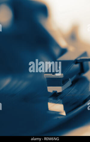 Close-up of a record player playing a vinyl record with colour toning Stock Photo