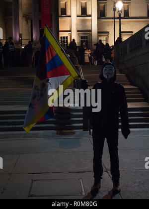 London, UK. 5th November 2018. Protester with the Tibetan flag and a Guy Fawkes mask seen on Trafalgar Square during the million mask march on the 5th of November 2018.  Credit: Joe Kuis / Alamy Live News Stock Photo