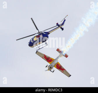 San Bernadino, ca, USA. 4th Nov, 2018. Stunt Pilots - AARON FITZGERALD flying the Red Bull Helicopter and KIRBY CHAMBLISS in the Red Bull Racing Stunt Plane performing a precision maneruver at SBDFest 2018, The San Bernadino Airport, San Bernadino, California, USA, November 4, 2018. Credit Image cr Scott Mitchell/ZUMA Press Credit: Scott Mitchell/ZUMA Wire/Alamy Live News Stock Photo