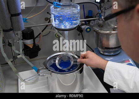 Holzminden, Germany. 23rd Oct, 2018. An employee of Symrise AG holds a sieve with 'ActiPearls' at the encapsulation system. Symrise is one of the world's leading suppliers of fragrances and flavors. Credit: Swen Pförtner/dpa/Alamy Live News Stock Photo