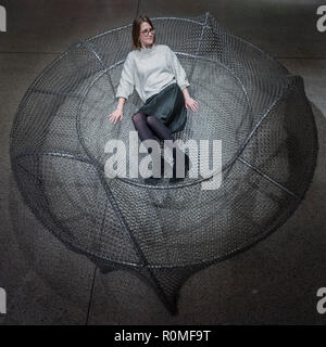 London, UK.  6 November 2018. A staff member sits on 'Frame 03', 2017, by SO-IL. Preview of 'Home Futures', at the Design Museum.  The exhibition, in partnership with IKEA Museum Almhult, asks are we living in the way that pioneering architects and designers once predicted, or has our idea of home proved resistant to real change.  More than 150 objects and experiences are on display 7 November to 24 March 2019.  Credit: Stephen Chung / Alamy Live News Stock Photo