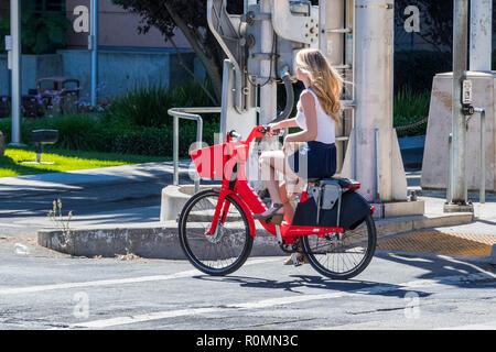 September 23, 2018 Sacramento / CA / USA - Girl riding a Jump electric bike; JUMP Bikes is a dockless electric bicycle sharing system acquired by UBER Stock Photo