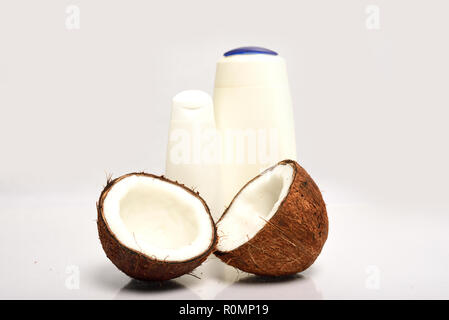 Close-up of Broken coconut and white bottle are isolated on white background Stock Photo