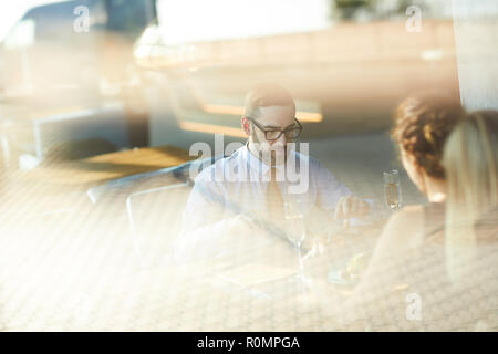 Young amorous couple having dinner or lunch in restaurant during date Stock Photo