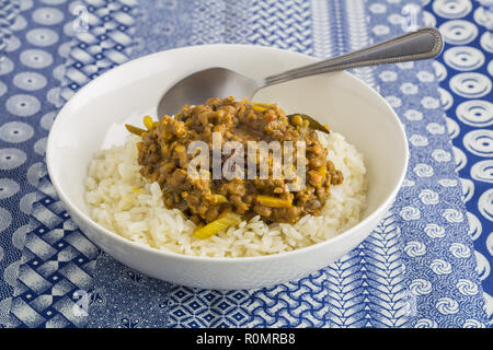 Lentil vegetable curry and rice close up on indigo ethnic printed blue and white tablecloth background