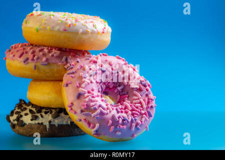Pile of colorful donuts on blue background. Stock Photo