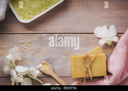 Spa setting with orchid, spoon,towel, soap, salt stones on old wooden background Stock Photo