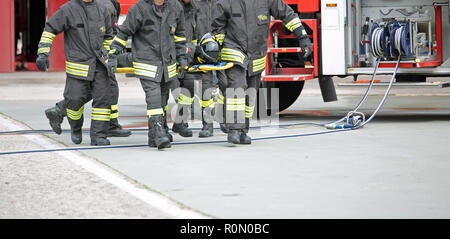 Italia, Italy - May 10, 2018: Italian firemen transport an injured on the stretcher during a practical roadside rescue exercise Stock Photo